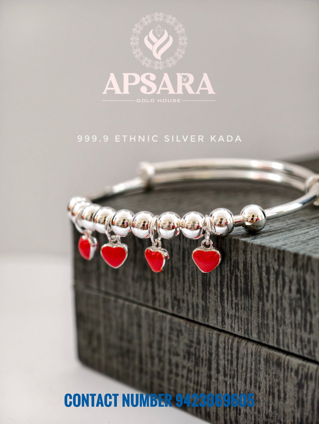 Silver kada featuring smooth round beads and hanging red heart charms.