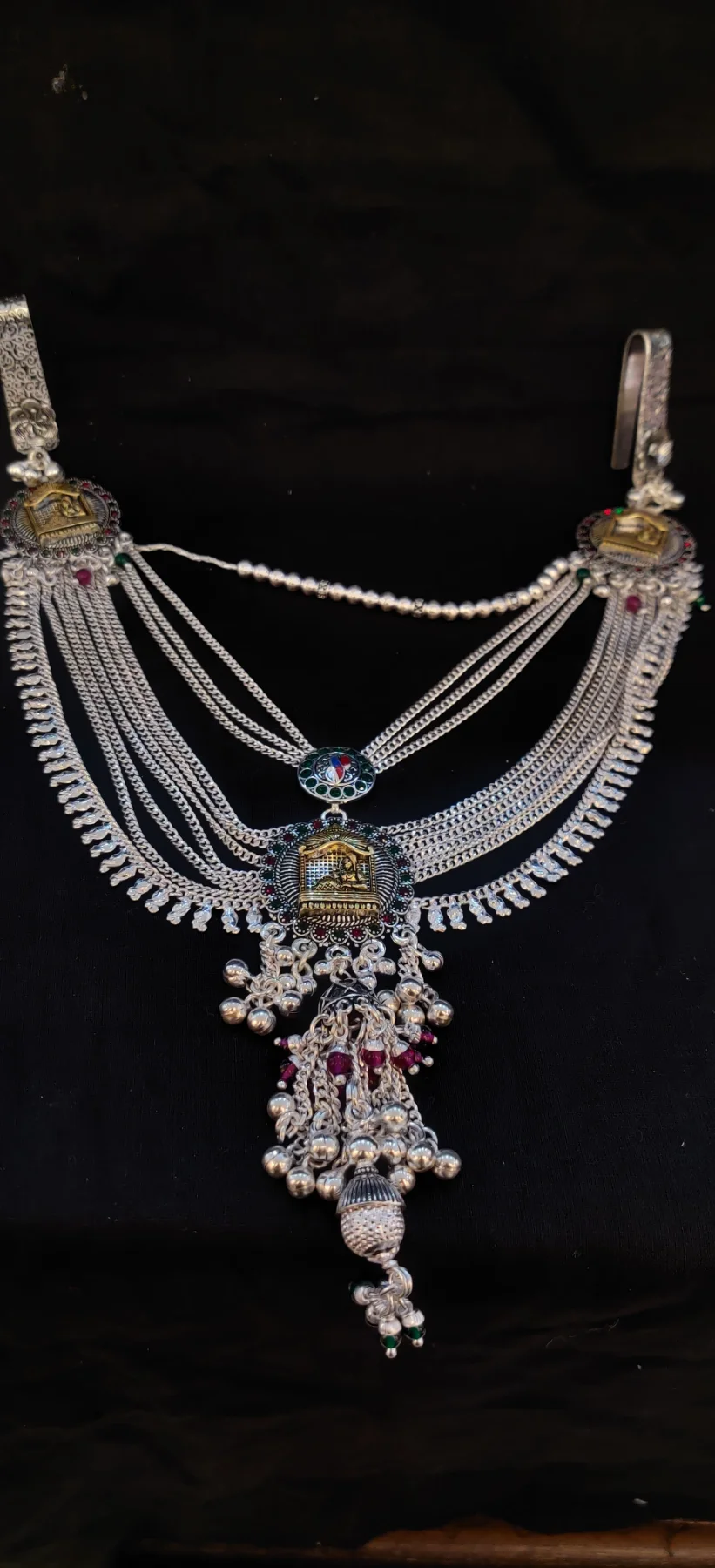 This multi-layered silver waist chain features traditional temple motifs with decorative dangles and small colourful beads.