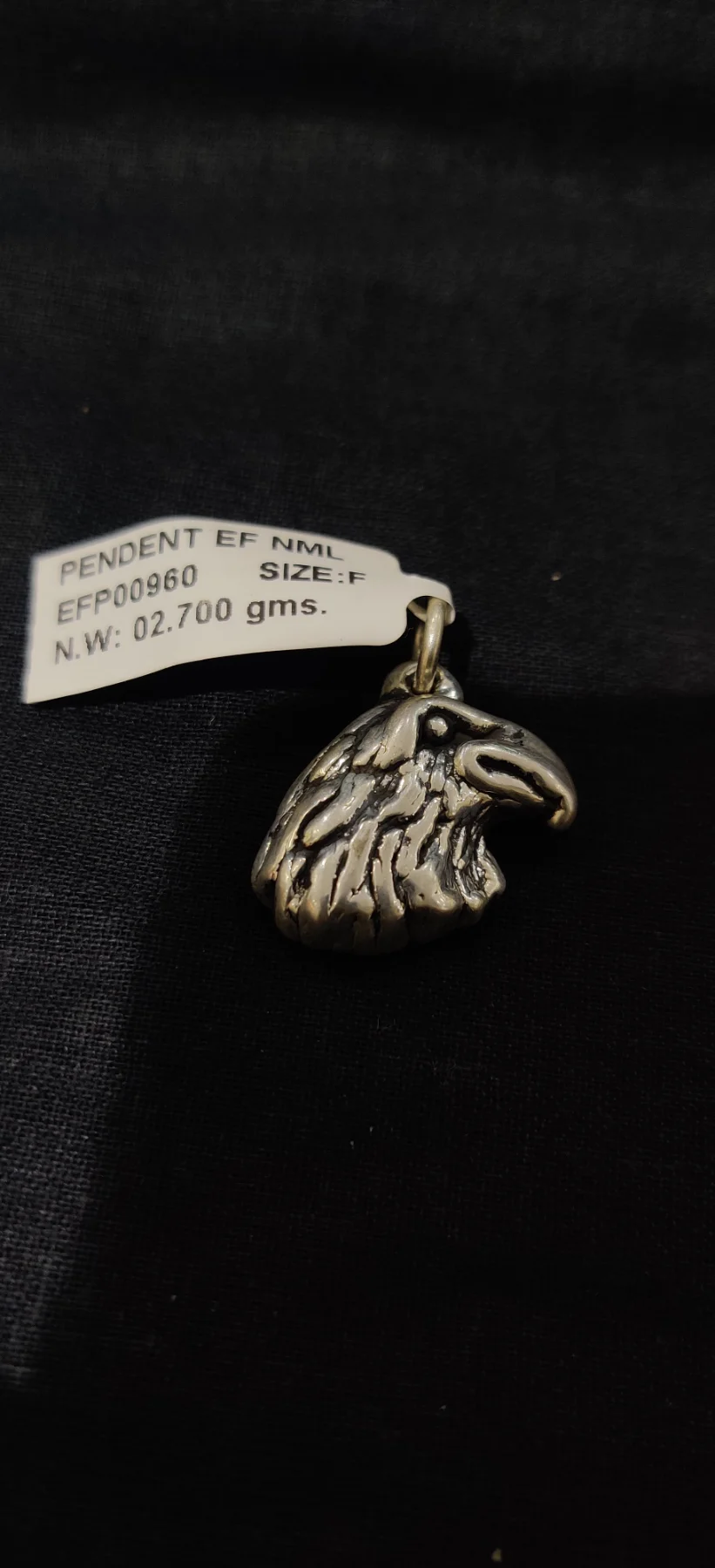 Oxidised silver eagle head locket with textured feather details and a loop for hanging.