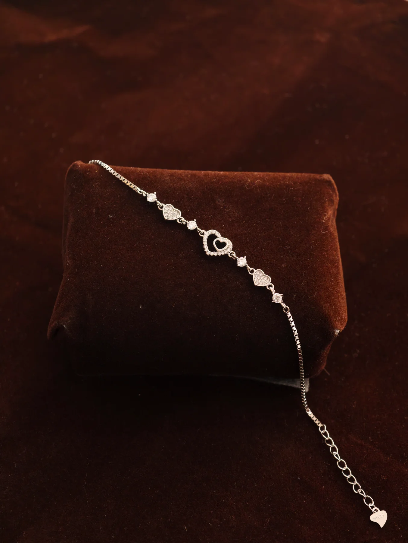 Delicate silver bracelet with sparkling stone-studded heart motifs and a fine chain.