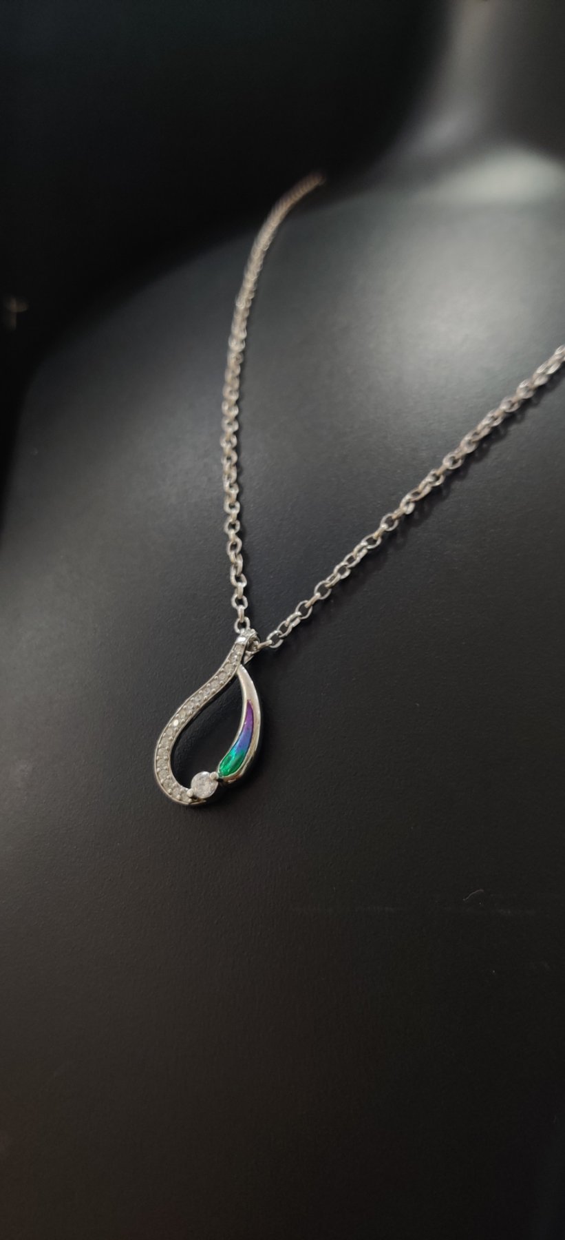 Elegant silver locket with white stones and colorful enamel detail on a matching chain.