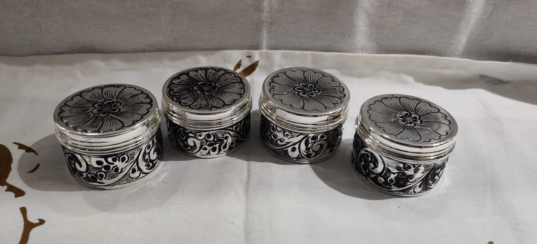 Round silver soap dish with engraved floral pattern and oxidised finish.