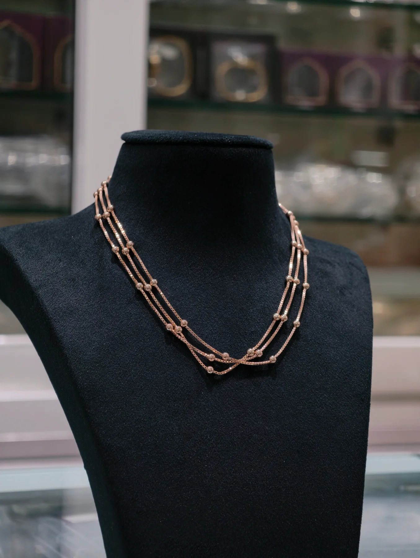 Three strand silver chain featuring evenly spaced round beads in a polished rose gold finish.