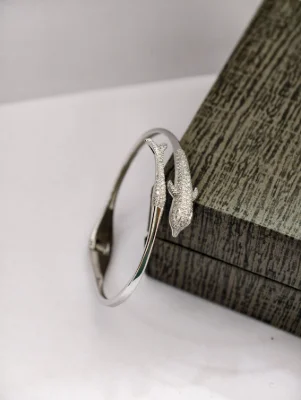 Silver snake bracelet featuring a detailed textured pattern and sparkling stones.