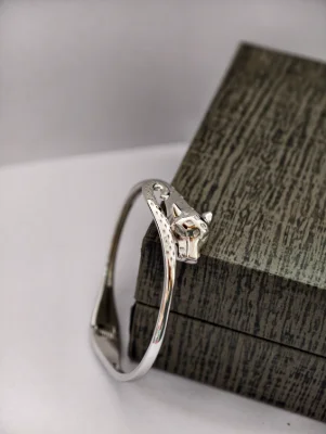 Polished silver bracelet featuring a detailed animal head motif with textured pattern along the band.