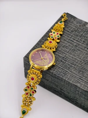 Gold polish silver watch featuring a purple dial with a peacock motif and intricately patterned floral links studded with stones.