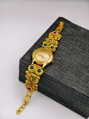 Gold polish silver watch bracelet featuring floral motifs, green and red stones, and a round dial.