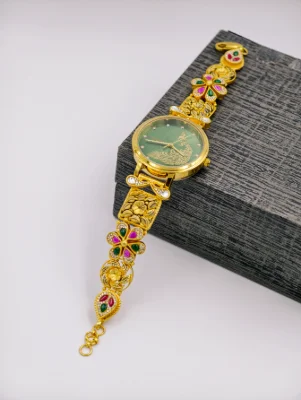 Gold polish silver watch featuring floral patterns, colorful stones, and a green dial with a peacock motif.