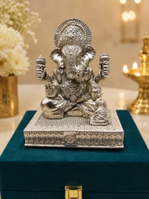 Detailed silver idol of Lord Ganesha seated on an ornate rectangular silver plaque with traditional floral motifs and fine detailing.