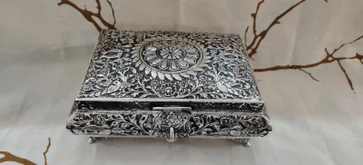 This silver betel nut set features intricate floral carvings with a polished and oxidised finish.