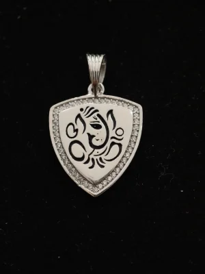 A shield shaped silver locket featuring a black etched Ganesha motif bordered with small white stones.