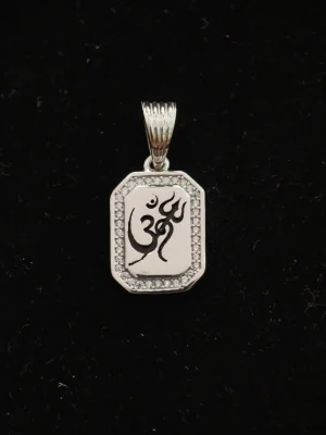 Silver worship locket featuring an om and trishul symbol, bordered with small sparkling stones.