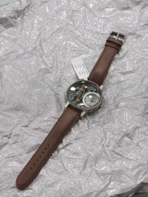 Silver luxury watch with round dial, brown leather strap, silver figure inside, and small round clock face.