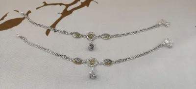 Silver fancy payal with double chain, floral center piece, small ghungroos, and dual finish styling.