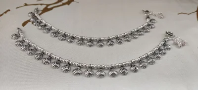 Silver payal featuring beaded chains and hanging ghungroo bells with oxidized finish.