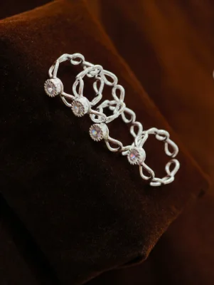 Silver toe rings featuring intertwined loop patterns and sparkling round white stones.