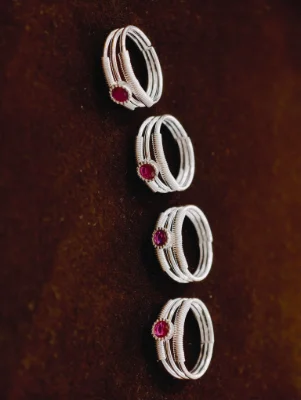 Silver bichhiya featuring three bands with wire wrap and a round red stone.