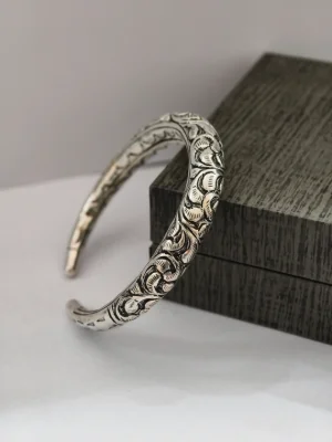 Silver kada featuring traditional engraved floral and geometric patterns with an oxidised finish.