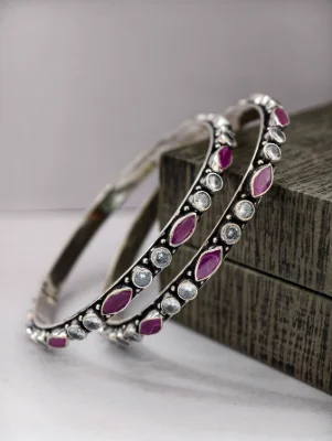 Oxidised silver bangles featuring alternating round white stones and marquise red stones.