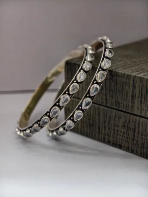 Oxidised silver bangles featuring a line of teardrop stones.