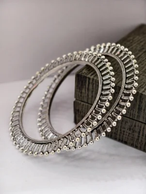 Round oxidised silver bangles featuring intricate wire patterns and small bead drops.