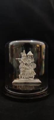 Detailed silver idol depicting deities playing instruments and carrying pots.
