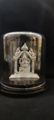 Solid silver idol of Lord Ganesha seated under an ornate arch with two birds.