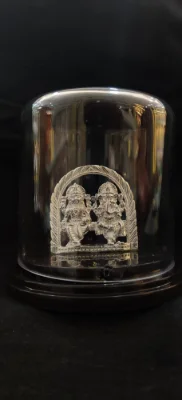 Solid silver idol featuring deities under a decorative arch with a shiny finish.