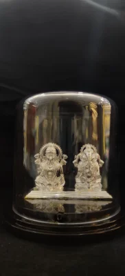 Solid silver idol featuring detailed figures of deities inside a protective dome.