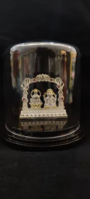Solid silver idol featuring Lakshmi and Ganesha under an arch, accented with red stones.