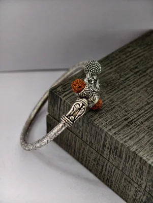 Oxidised silver kada featuring a Trishul symbol, brown rudraksha beads, and a textured pattern.