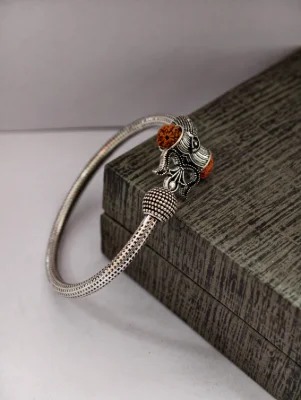 Oxidised silver kada featuring a Mahakal motif and brown rudraksha beads with detailed texture and design.