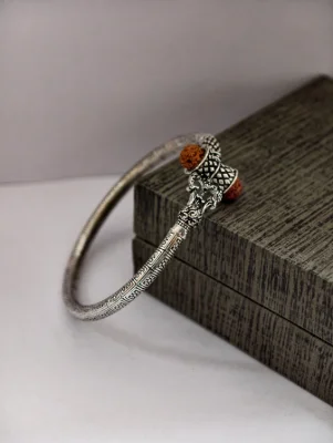 Oxidised silver kada featuring detailed geometric patterns, traditional motifs, and brown rudraksha beads.