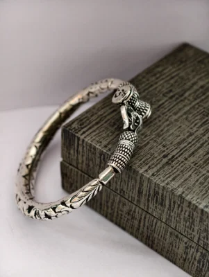 Oxidised silver kada with intricate floral patterns, om symbol, and textured beaded ends.