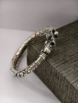 Oxidised silver kada with intricate floral patterns and a detailed Mahakal design.