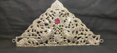 Intricate silver crown featuring peacock motifs, floral filigree work, and a central red stone.