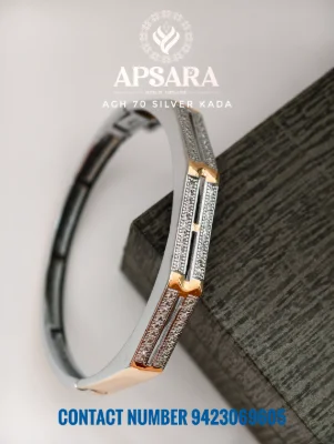A silver fancy kada featuring studded small stones, a grooved pattern, and polished gold accents.
