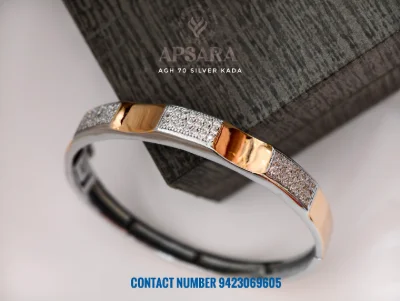A silver kada featuring alternate sections of sparkling white stones and smooth rose gold polish.