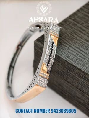 Silver kada featuring dual tone rose gold polish, white stones, and a central line of black stones.