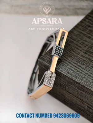 A silver kada featuring rose gold polish, square stone settings with black and white stones, and a sleek geometric design.