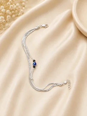 A multi strand silver bracelet featuring an evil eye bead and black beads.