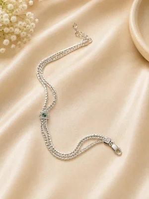 Delicate silver bracelet featuring multiple thin textured chains and a small square centerpiece with green stones.