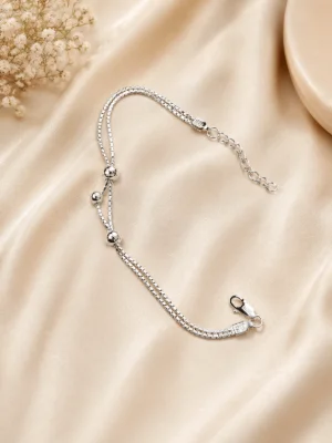 A double layer silver bracelet featuring square link chains and glossy round metal beads.