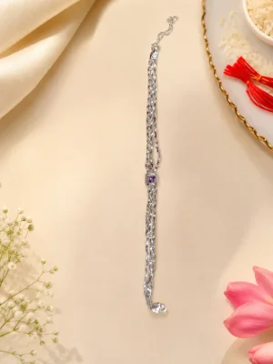 This is a delicate silver bracelet featuring multiple linked chains and a small gemstone centrepiece.