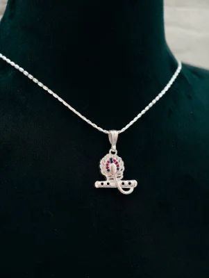 Silver chain with a peacock feather and flute locket featuring red and blue stones.