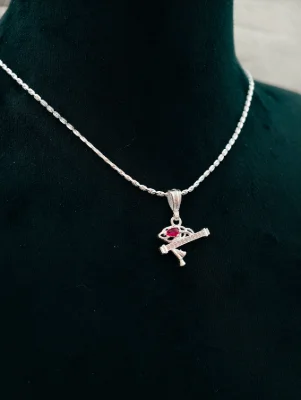 Silver chain with Lord Krishna pendant featuring a red stone and white stones.