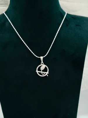 Silver chain with round locket featuring flute and peacock feather design.
