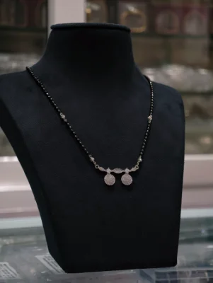 Elegant silver mangalsutra featuring a double pendant set with sparkling stones and black beaded chain.