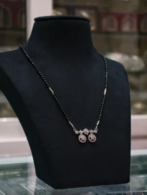 Elegant silver dorla mangalsutra featuring a double round pendant set with white stones and black beaded chain.