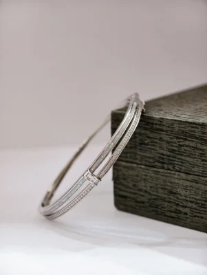 Silver stone kada bracelet featuring white stones and opal style inserts in a sleek design.